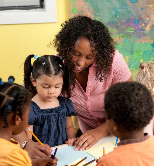 A KALE teacher guiding children through a hands-on art lesson